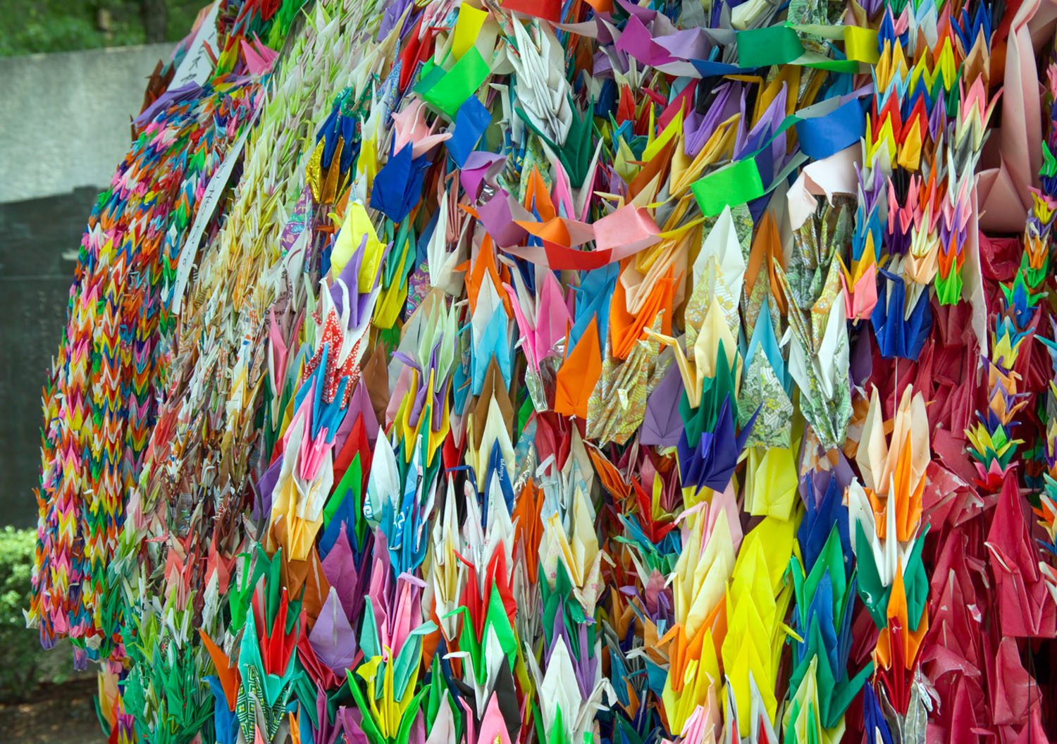 Strings of brightly colored paper cranes left as offerings in Hiroshima