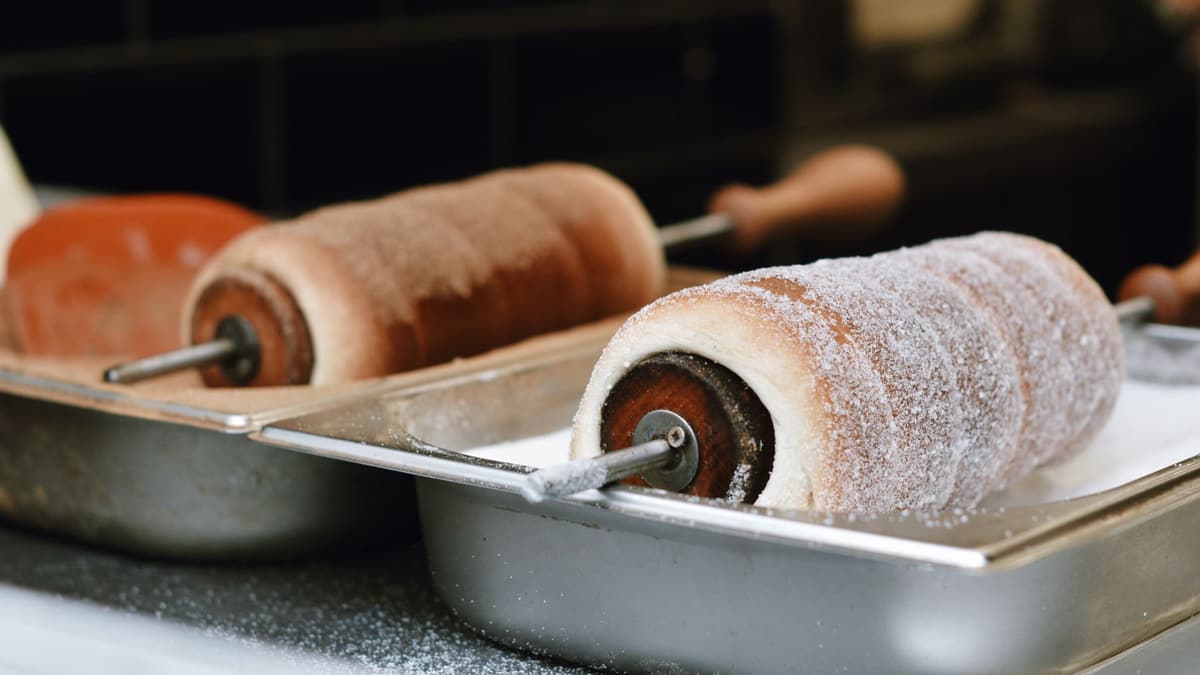 Chimney cakes on spits, dusted with sugar
