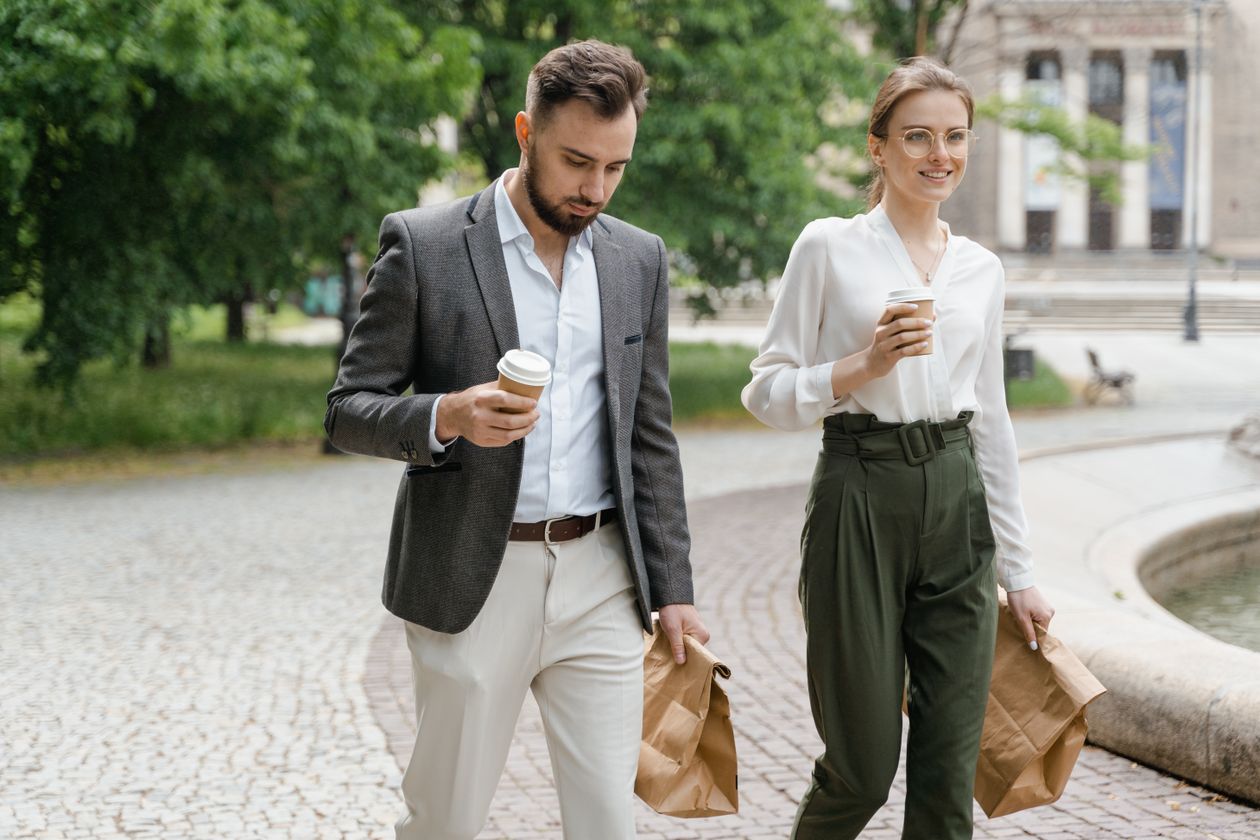 Two colleagues walking through a park on a lunch break