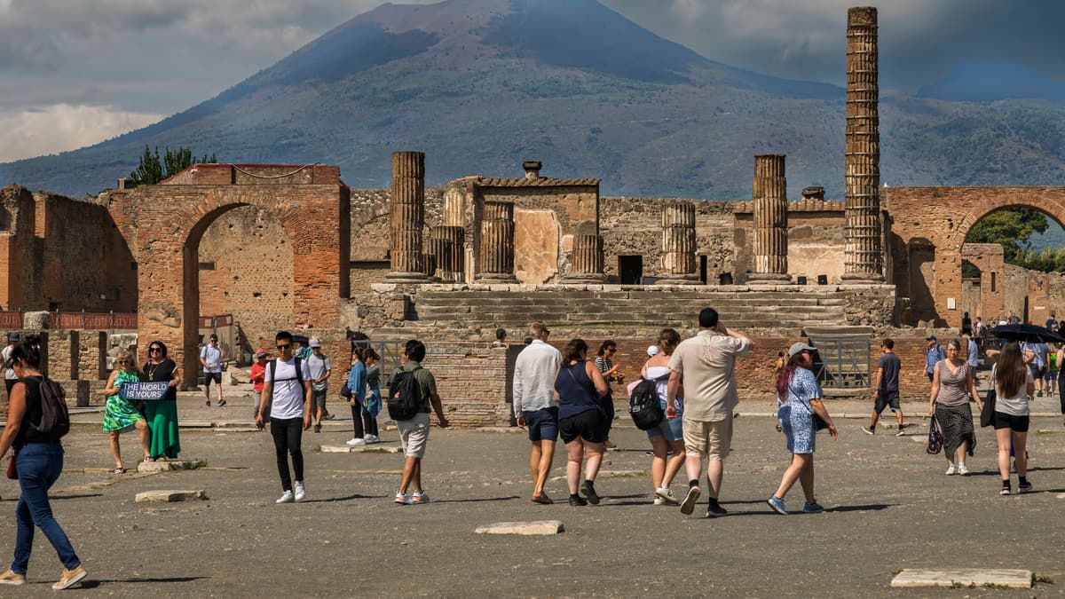 Visitors among the ruins of Pompeii, with Vesuvius behind