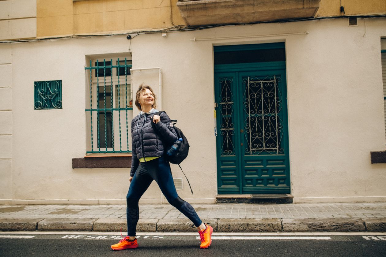 A walker striding along a city street